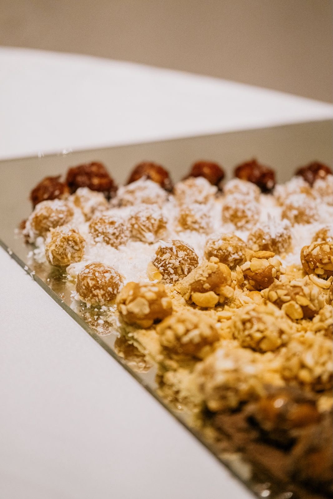 Detalhe aproximado da mesa de doces, com brigadeiros de coco e de amendoim.